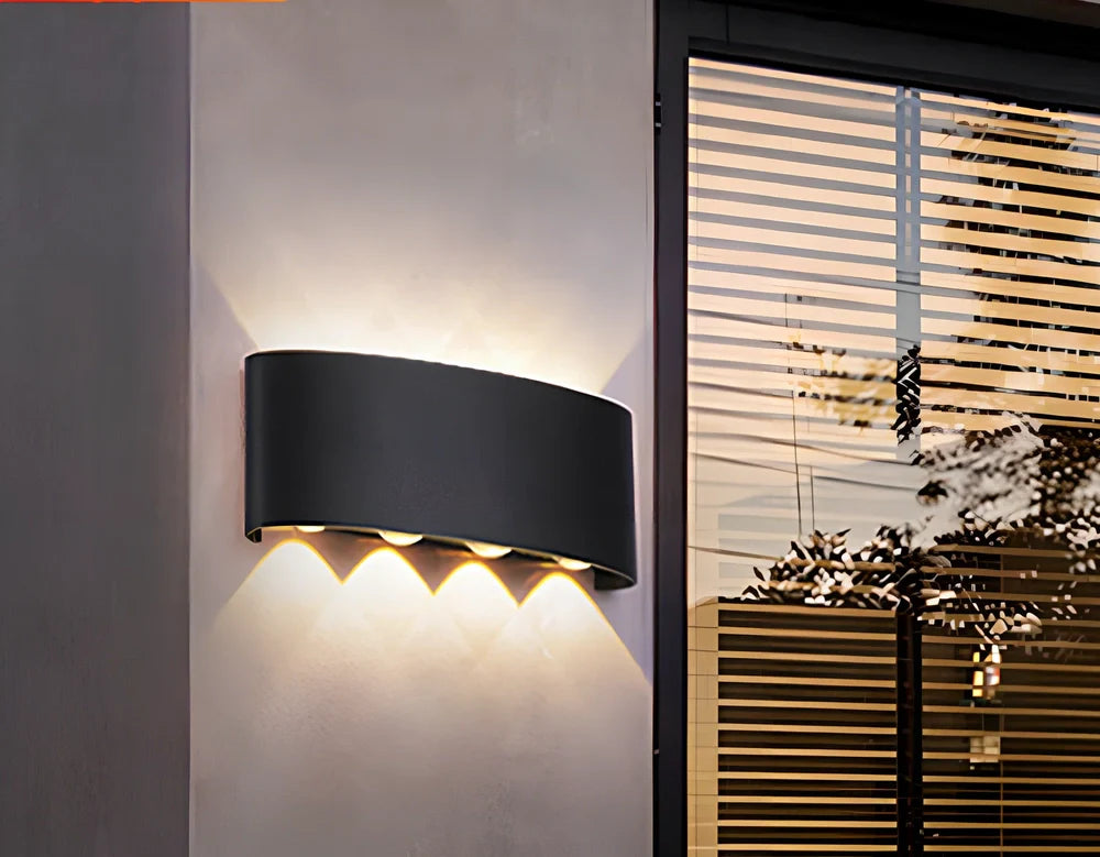Black outdoor LED wall lamp with aluminium shell mounted on a wall, showing compact design and rainproof IP65 rating
