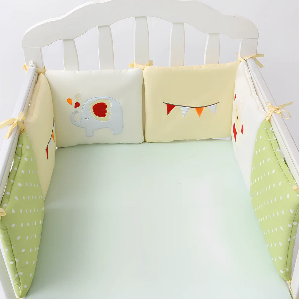 Six 30cm square cotton baby bedding panels with animal patterns surrounding white cot