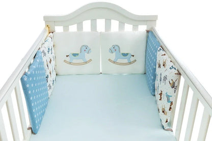 Six 30cm square cotton baby bedding panels with animal patterns surrounding white cot