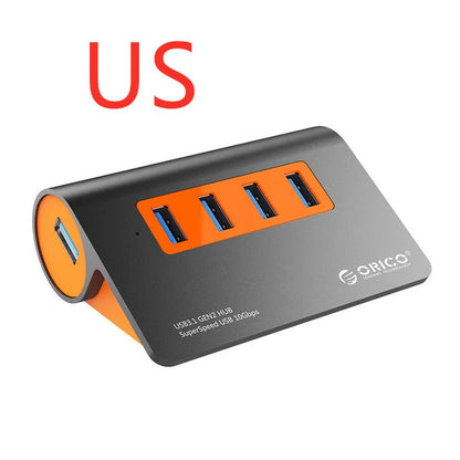 Dark grey aluminium USB-C laptop docking station with orange accents, showing USB ports, HDMI, and card readers.
