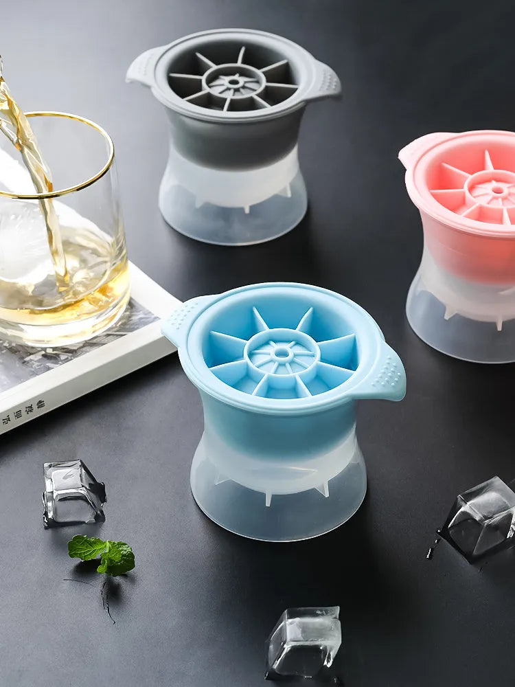 Silicone ice tray in various colours making large ice cubes, including hockey puck and geometric shapes, on a kitchen counter