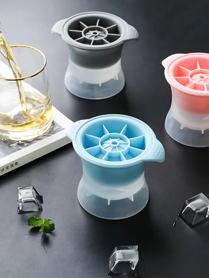 Silicone ice tray in various colours making large ice cubes, including hockey puck and geometric shapes, on a kitchen counter