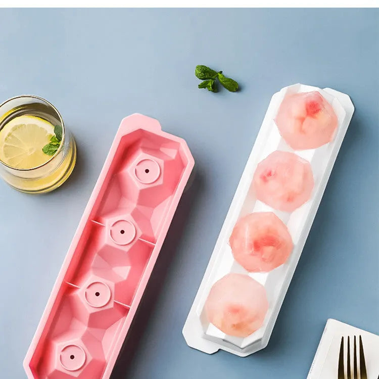 Silicone ice tray in various colours making large ice cubes, including hockey puck and geometric shapes, on a kitchen counter
