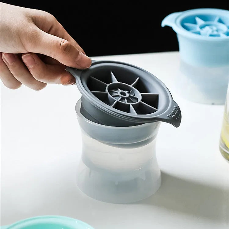 Silicone ice tray in various colours making large ice cubes, including hockey puck and geometric shapes, on a kitchen counter