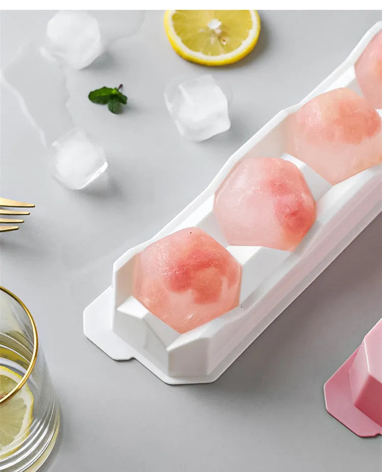 Silicone ice tray in various colours making large ice cubes, including hockey puck and geometric shapes, on a kitchen counter