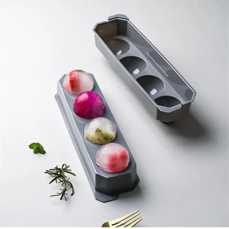 Silicone ice tray in various colours making large ice cubes, including hockey puck and geometric shapes, on a kitchen counter