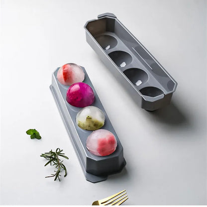 Silicone ice tray in various colours making large ice cubes, including hockey puck and geometric shapes, on a kitchen counter