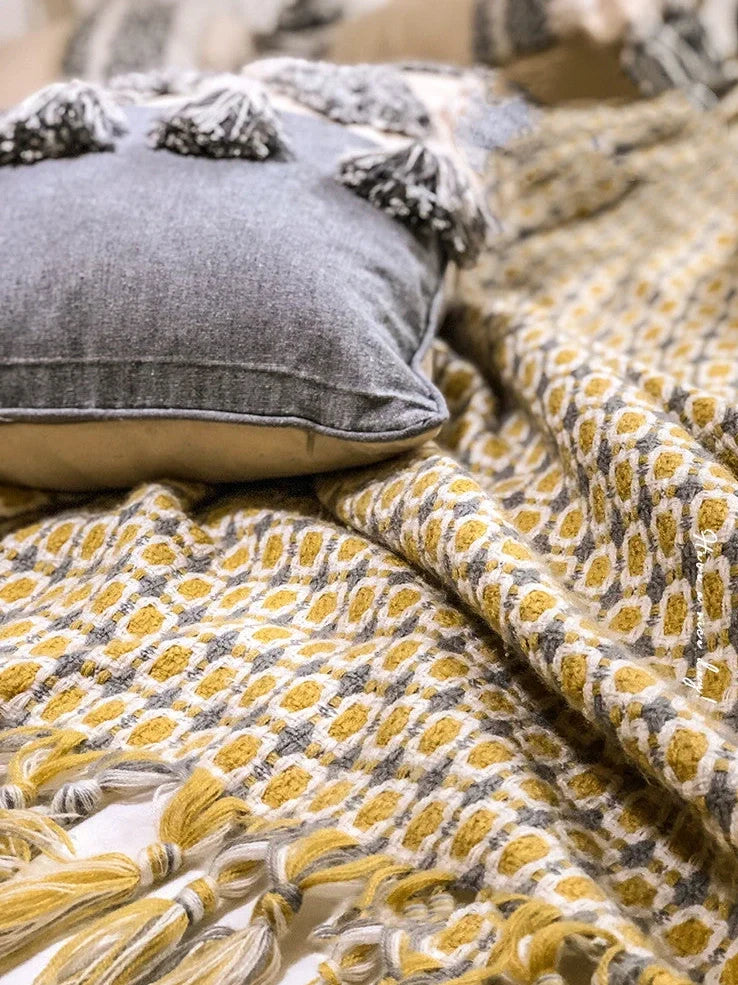 Yellow geometric pattern blanket measuring 130cm by 152cm with tassel edges