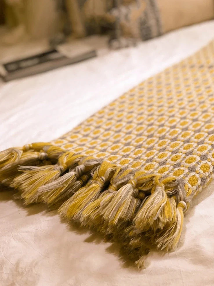 Yellow geometric pattern blanket measuring 130cm by 152cm with tassel edges