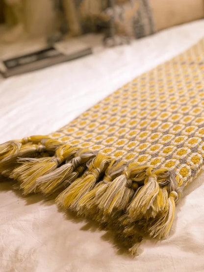 Yellow geometric pattern blanket measuring 130cm by 152cm with tassel edges
