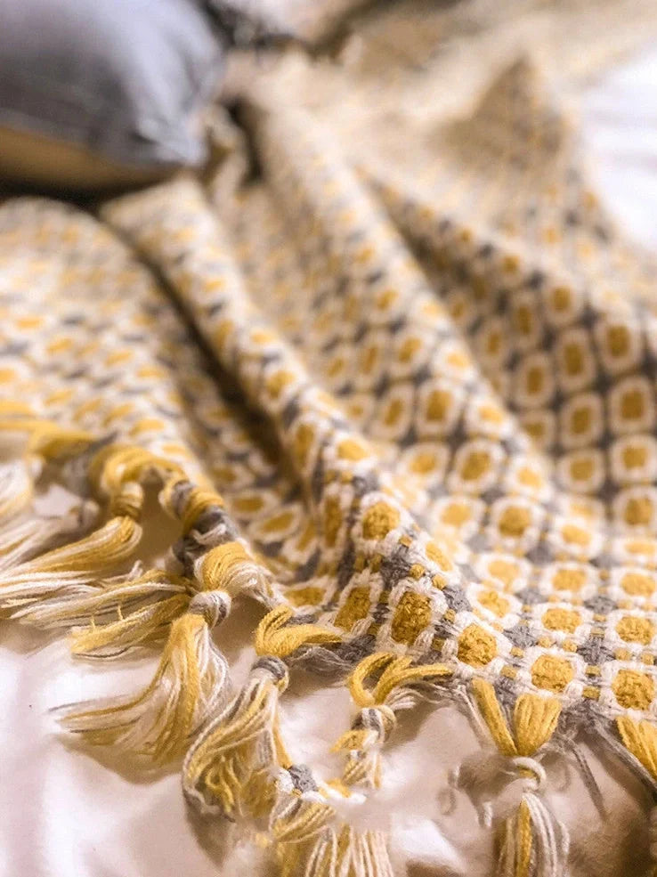 Yellow geometric pattern blanket measuring 130cm by 152cm with tassel edges