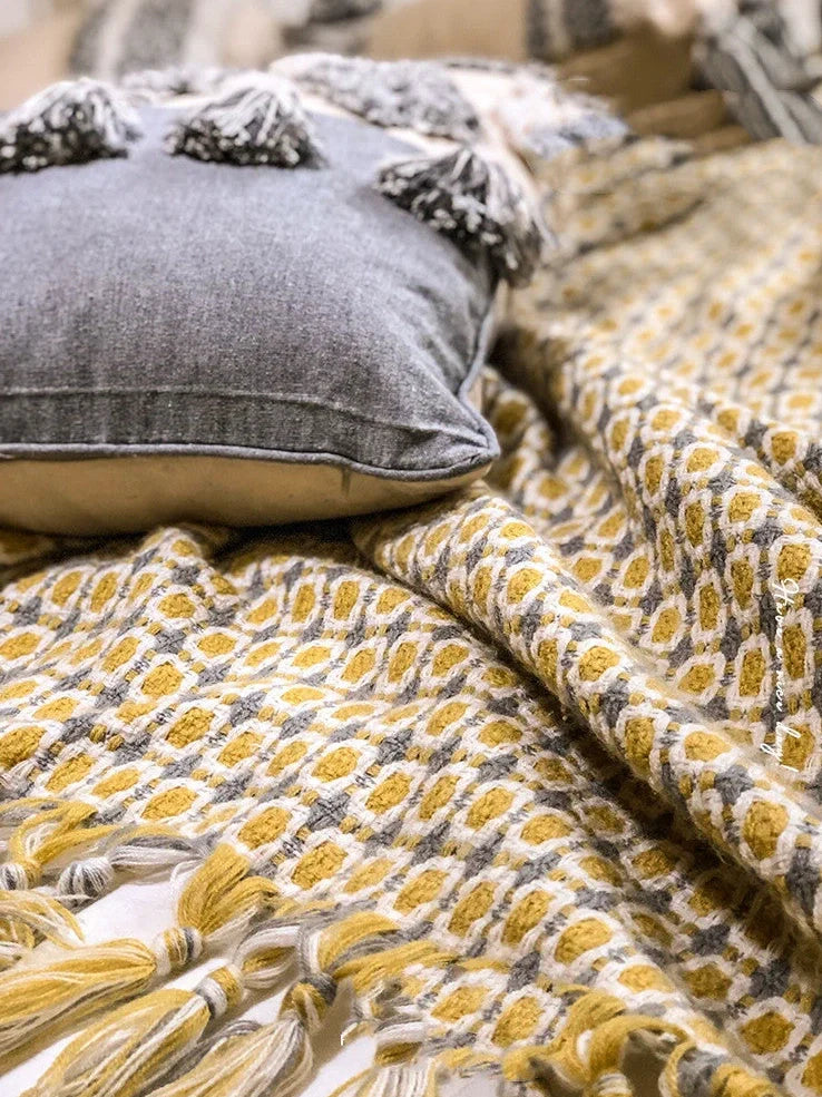 Yellow geometric pattern blanket measuring 130cm by 152cm with tassel edges