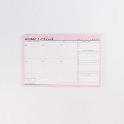 Domikee student desk organiser pad in pink and green with integrated weekly and monthly paper planners.