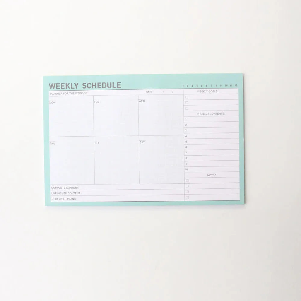 Domikee student desk organiser pad in pink and green with integrated weekly and monthly paper planners.