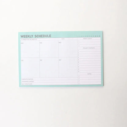 Domikee student desk organiser pad in pink and green with integrated weekly and monthly paper planners.