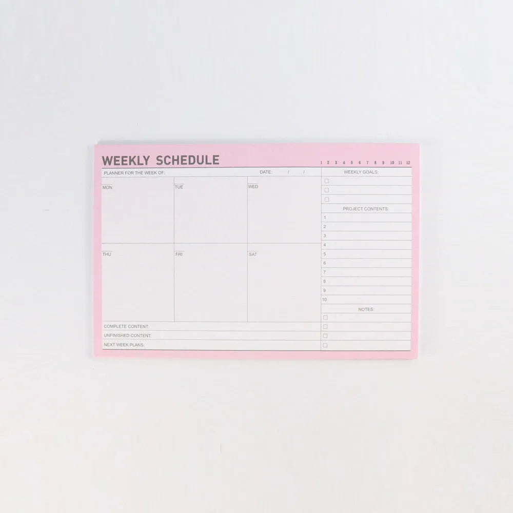 Domikee student desk organiser pad in pink and green with integrated weekly and monthly paper planners.