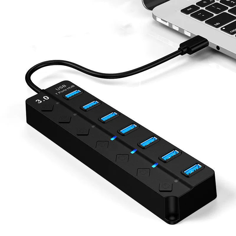 Black 7-port USB 3.0 hub with external power adapter on desktop