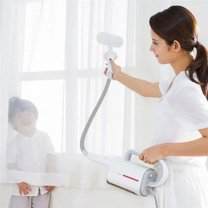 White Deerma handheld steam cleaner with multiple brush heads and extension tubes on a table