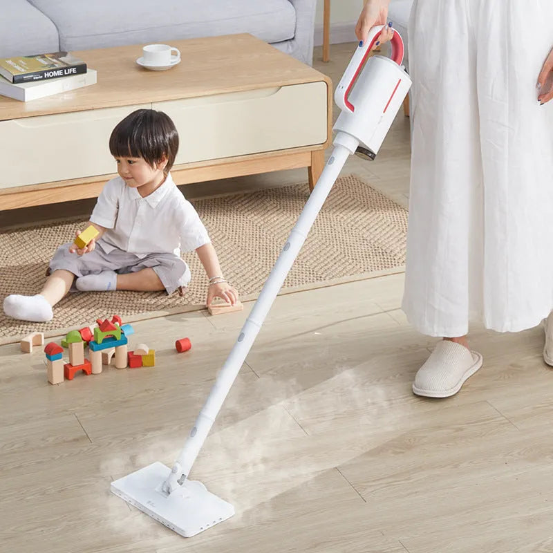 White Deerma handheld steam cleaner with multiple brush heads and extension tubes on a table