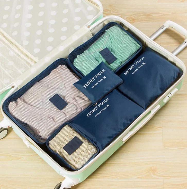 Set of six coloured nylon packing cubes and flat pouches for travel organisation.