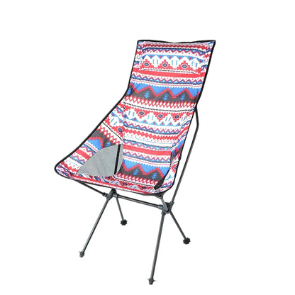 Red aluminium alloy folding moon chair unfolded on grass with folding mechanism visible
