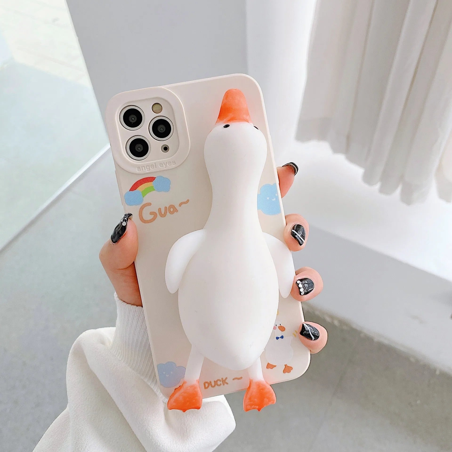 Cartoon print silicone phone case for iPhone in yellow, white, and pink colours.