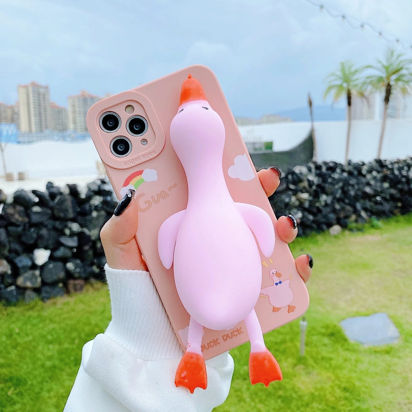 Cartoon print silicone phone case for iPhone in yellow, white, and pink colours.