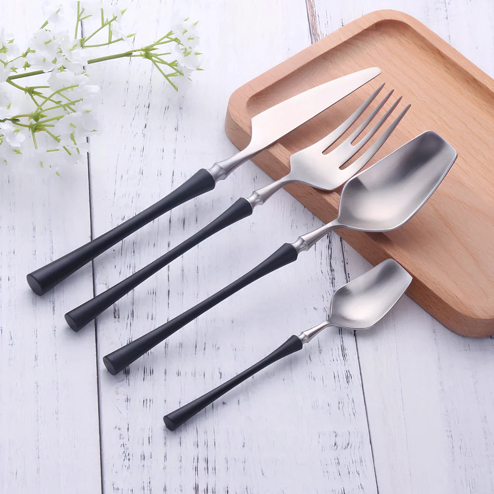 Four-piece stainless steel cutlery set showing main knife, fork, spoon, and teaspoon with mirror finish