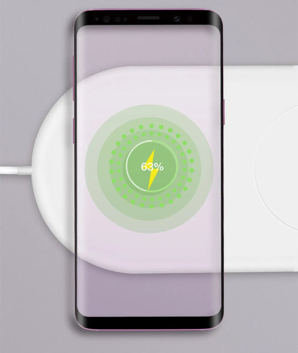 White dual wireless fast charging pad for two mobile phones on a wooden desk.