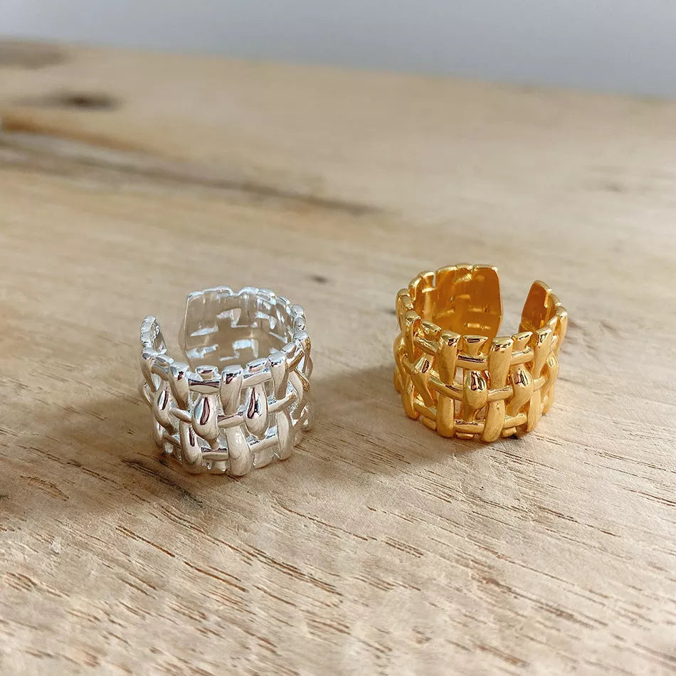 Woven brass ring with hollow cross design for women, available in gold and silver.