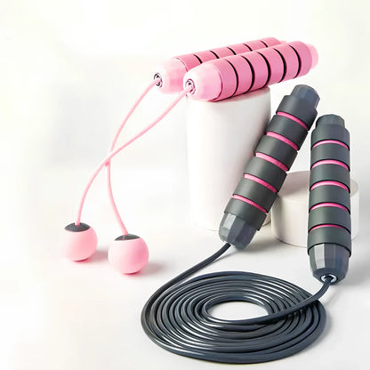 Pink and grey skipping rope with weighted handles and adjustable length mechanism for fitness training
