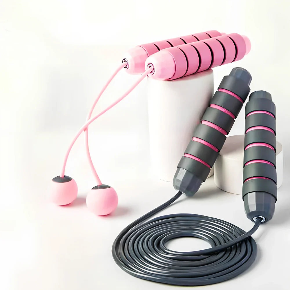 Pink and grey skipping rope with weighted handles and adjustable length mechanism for fitness training