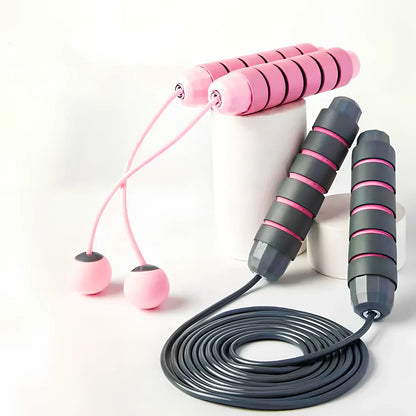 Pink and grey skipping rope with weighted handles and adjustable length mechanism for fitness training