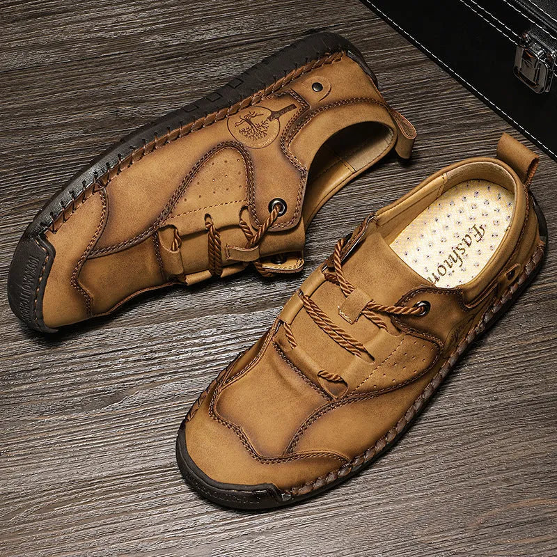 Men's plain black casual leather shoes with round toe and microfiber upper on a wooden floor.