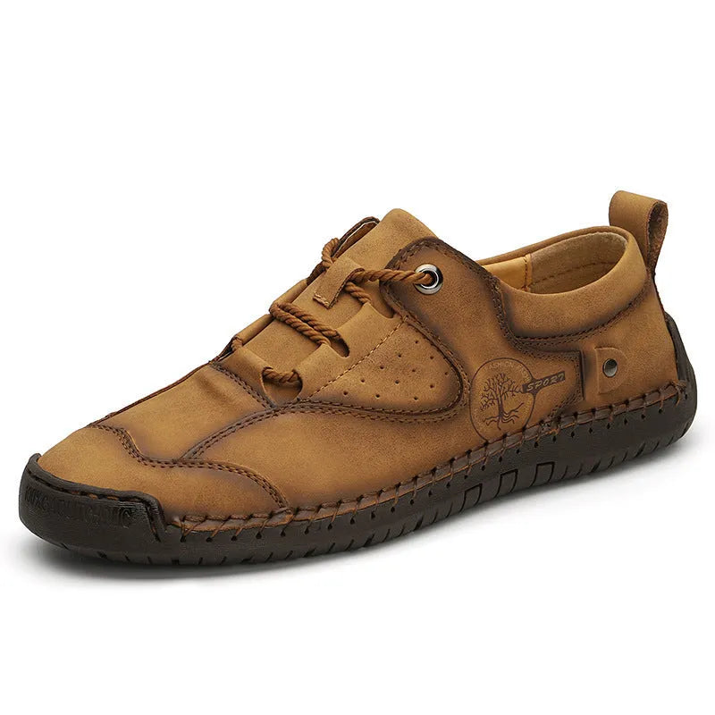 Men's plain black casual leather shoes with round toe and microfiber upper on a wooden floor.