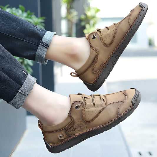 Men's plain black casual leather shoes with round toe and microfiber upper on a wooden floor.