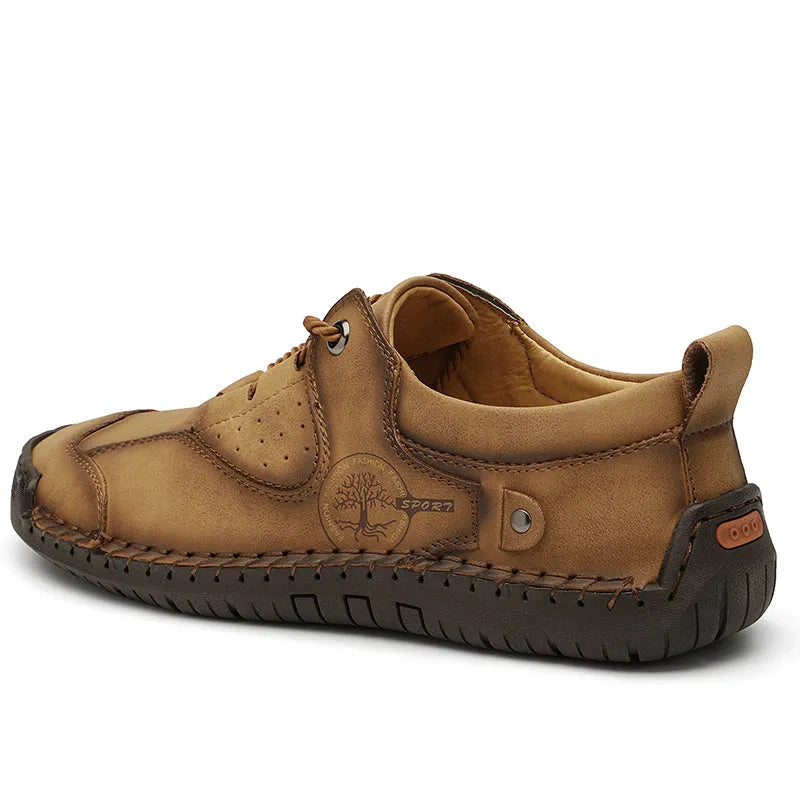 Men's plain black casual leather shoes with round toe and microfiber upper on a wooden floor.