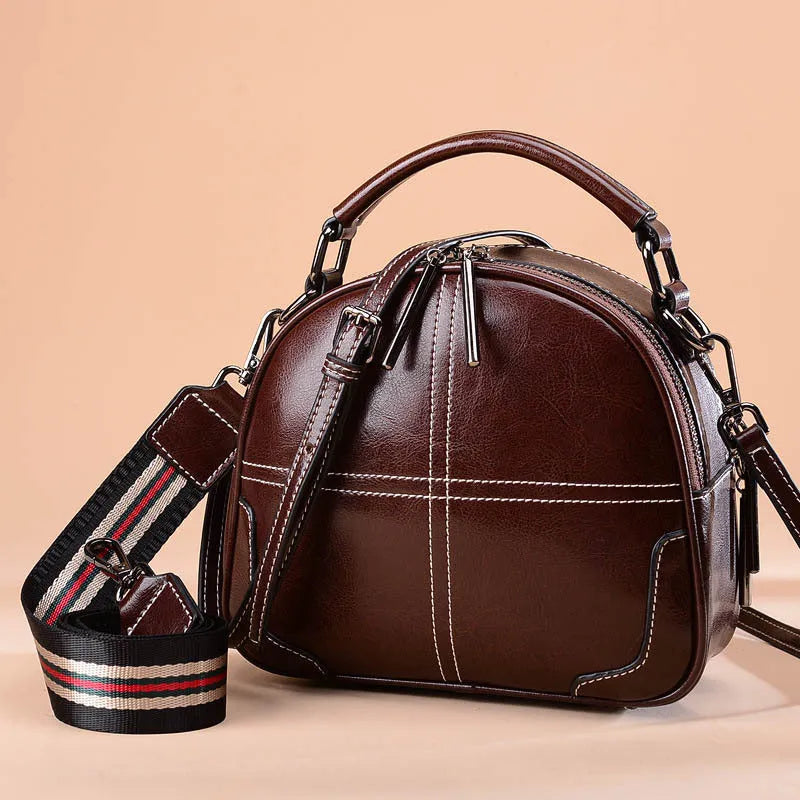 Round leather handbag in wine red with soft handle, measuring 21cm wide and 18.5cm high, featuring a zipper opening.