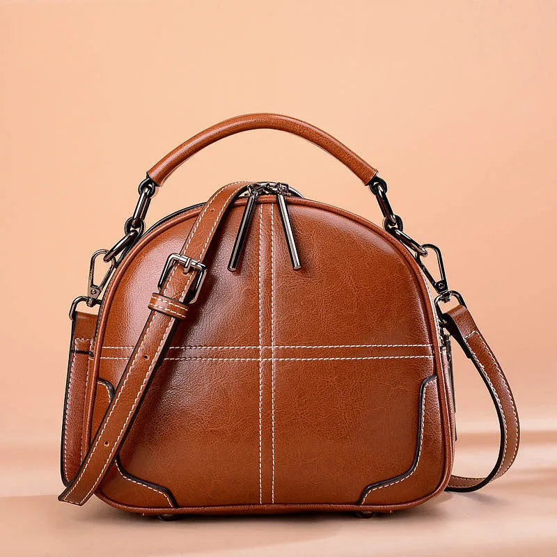 Round leather handbag in wine red with soft handle, measuring 21cm wide and 18.5cm high, featuring a zipper opening.