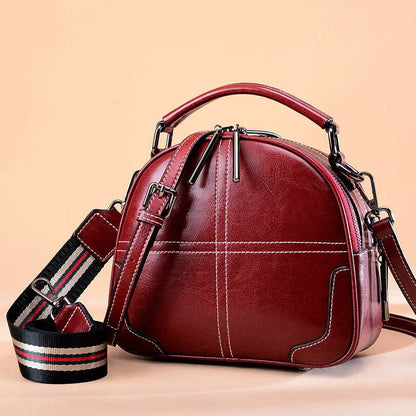 Round leather handbag in wine red with soft handle, measuring 21cm wide and 18.5cm high, featuring a zipper opening.