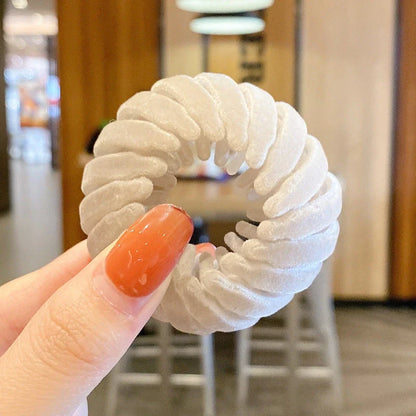 Adjustable ponytail hair accessory with flexible teeth, available in various colors, designed for easy, natural-looking hairstyles