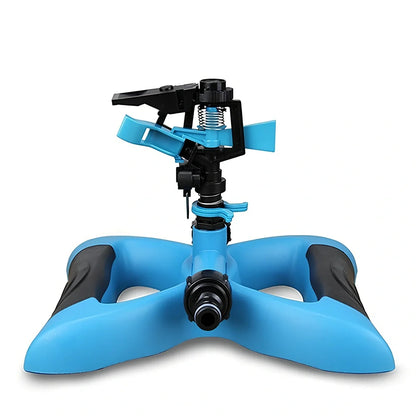 Blue butterfly-shaped garden sprinkler with rotating nozzle on grass