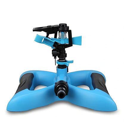 Blue butterfly-shaped garden sprinkler with rotating nozzle on grass