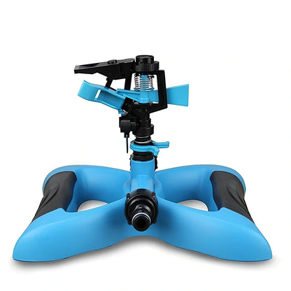 Blue butterfly-shaped garden sprinkler with rotating nozzle on grass