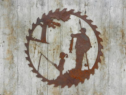 Handcrafted metal pendant with a father and child fishing scene, set in a circular saw blade frame