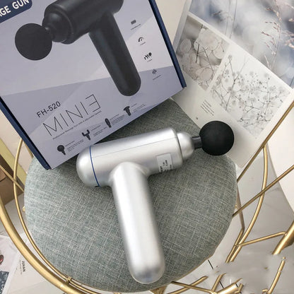 Grey handheld percussion muscle massager with USB charging port and rubberised grip