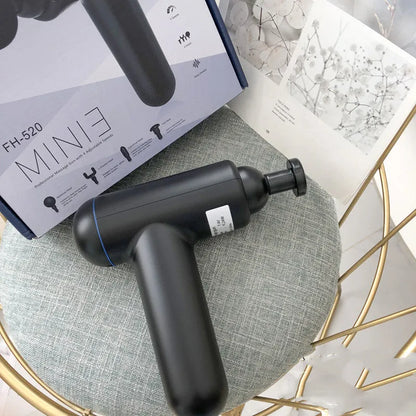 Grey handheld percussion muscle massager with USB charging port and rubberised grip