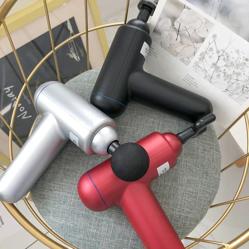 Grey handheld percussion muscle massager with USB charging port and rubberised grip