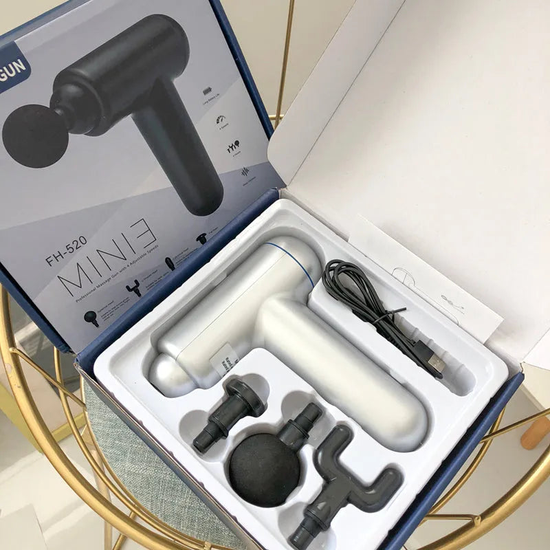 Grey handheld percussion muscle massager with USB charging port and rubberised grip