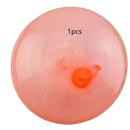 Large pink, yellow, green, and blue inflatable bouncy balls in various sizes for children's play.